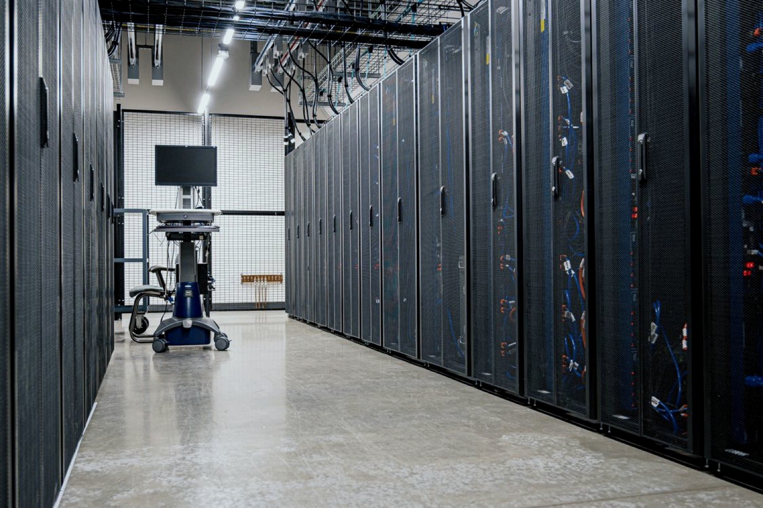 Data center aisle with server cabinets and a rolling console